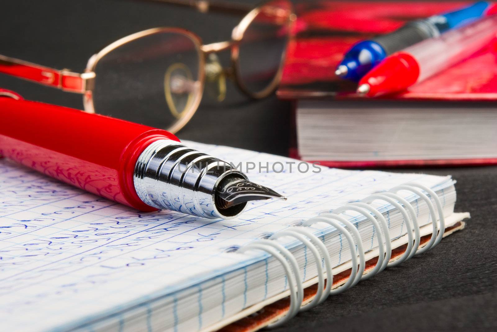 
Red ink pen lying on a notebook