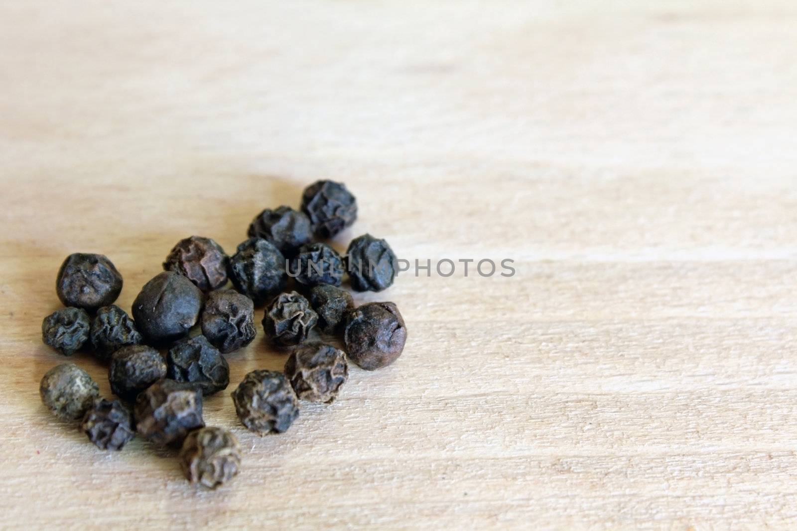 Black Pepper grains in the bottom left corner of the chopping board