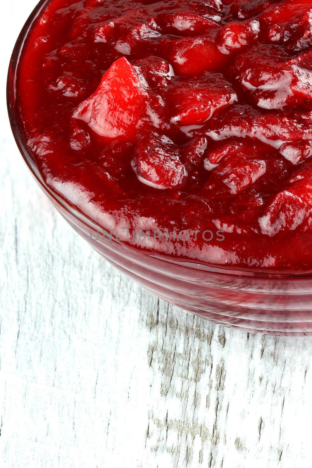 Fresh cranberry apple sauce over a white rustic background. Shallow depth of field.


