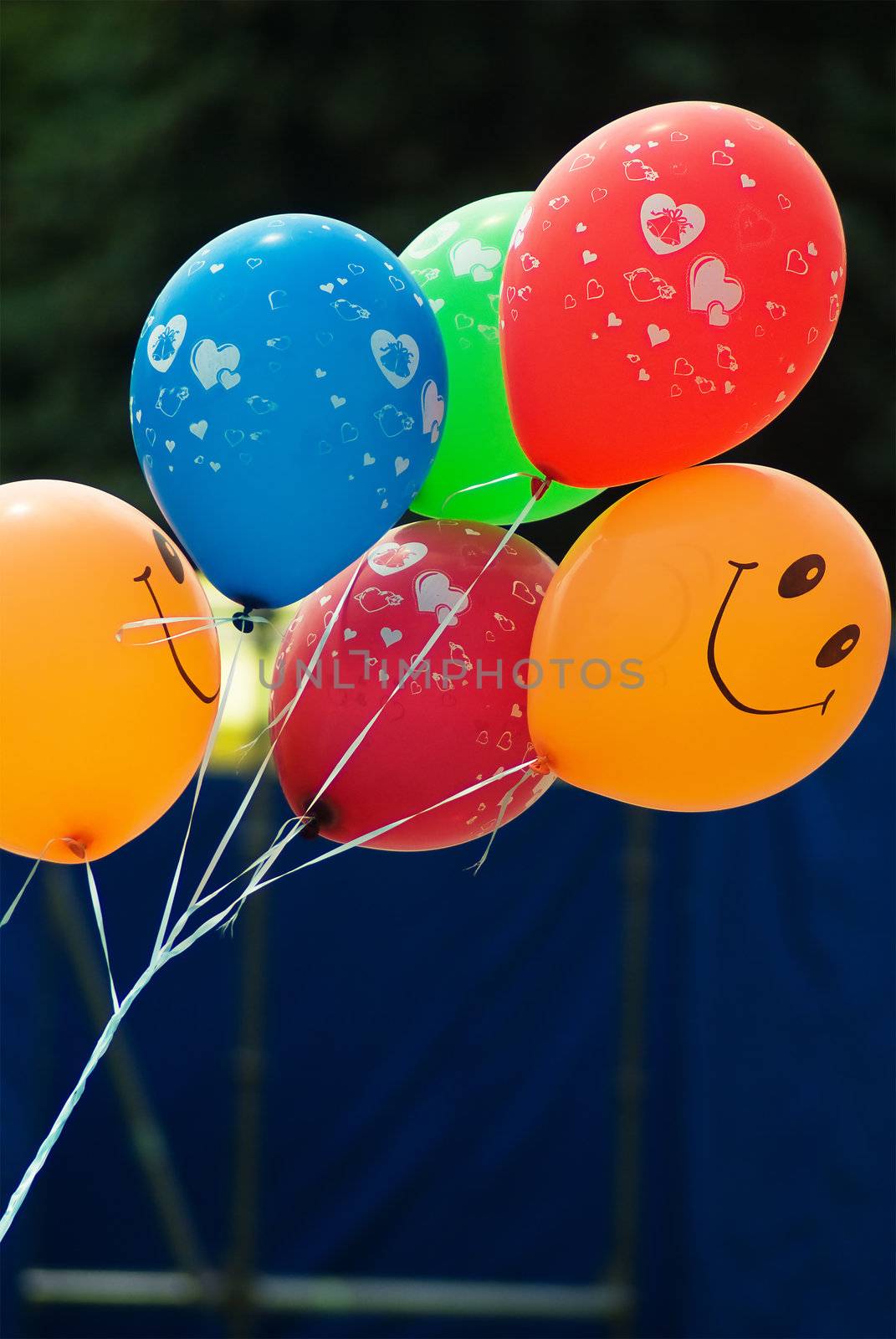 A smiley faced balloon against a dark background