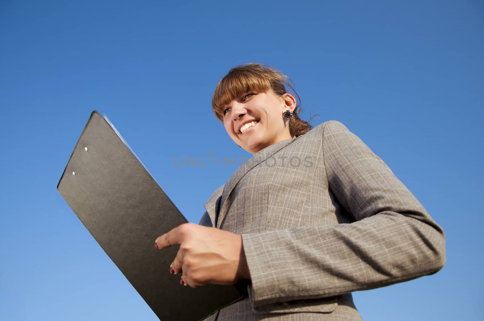 business woman on the tablet and smiles at the blue sky