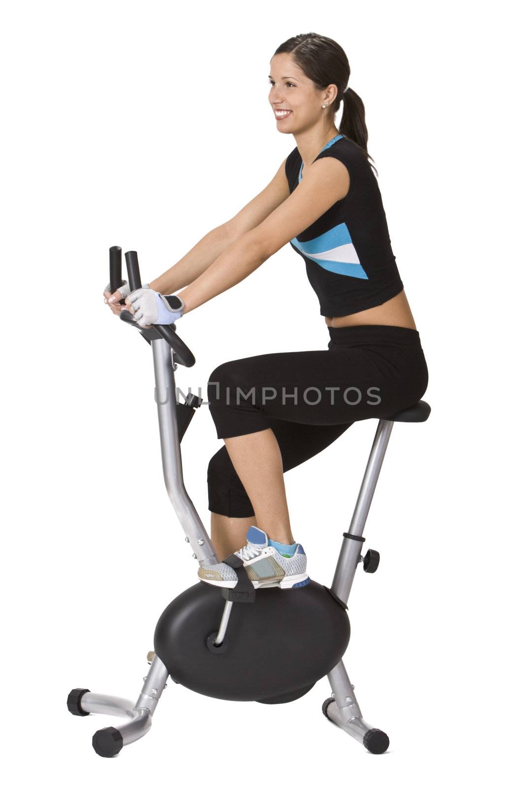Girl riding a fitness bicycle against a white background.