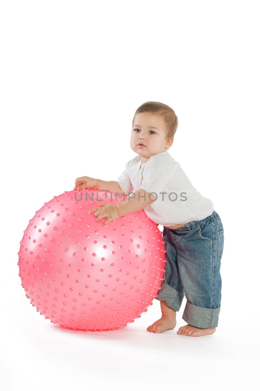A little boy with a big pink fitness ball