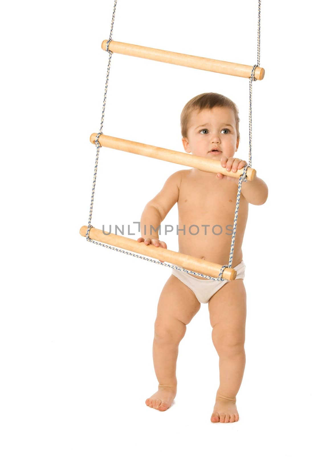 A little boy trying to climb a rope-ladder
