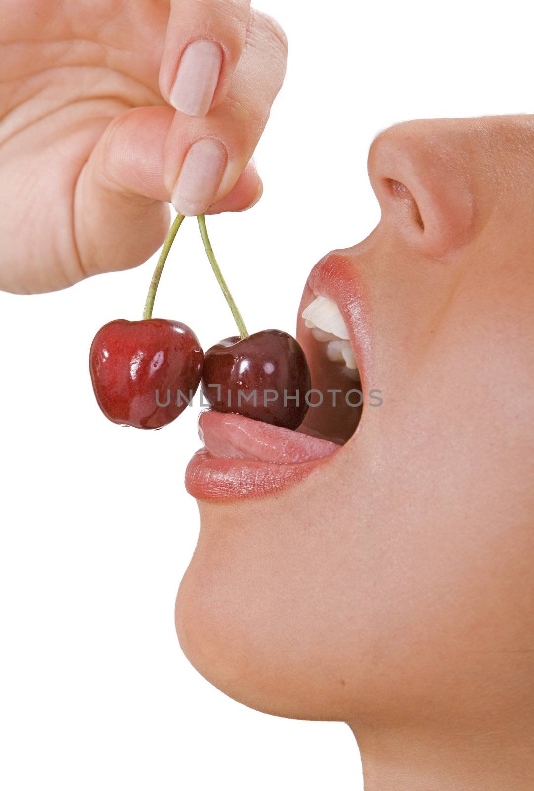Close-up of a woman's open mouth with cherries isolated against a white background.