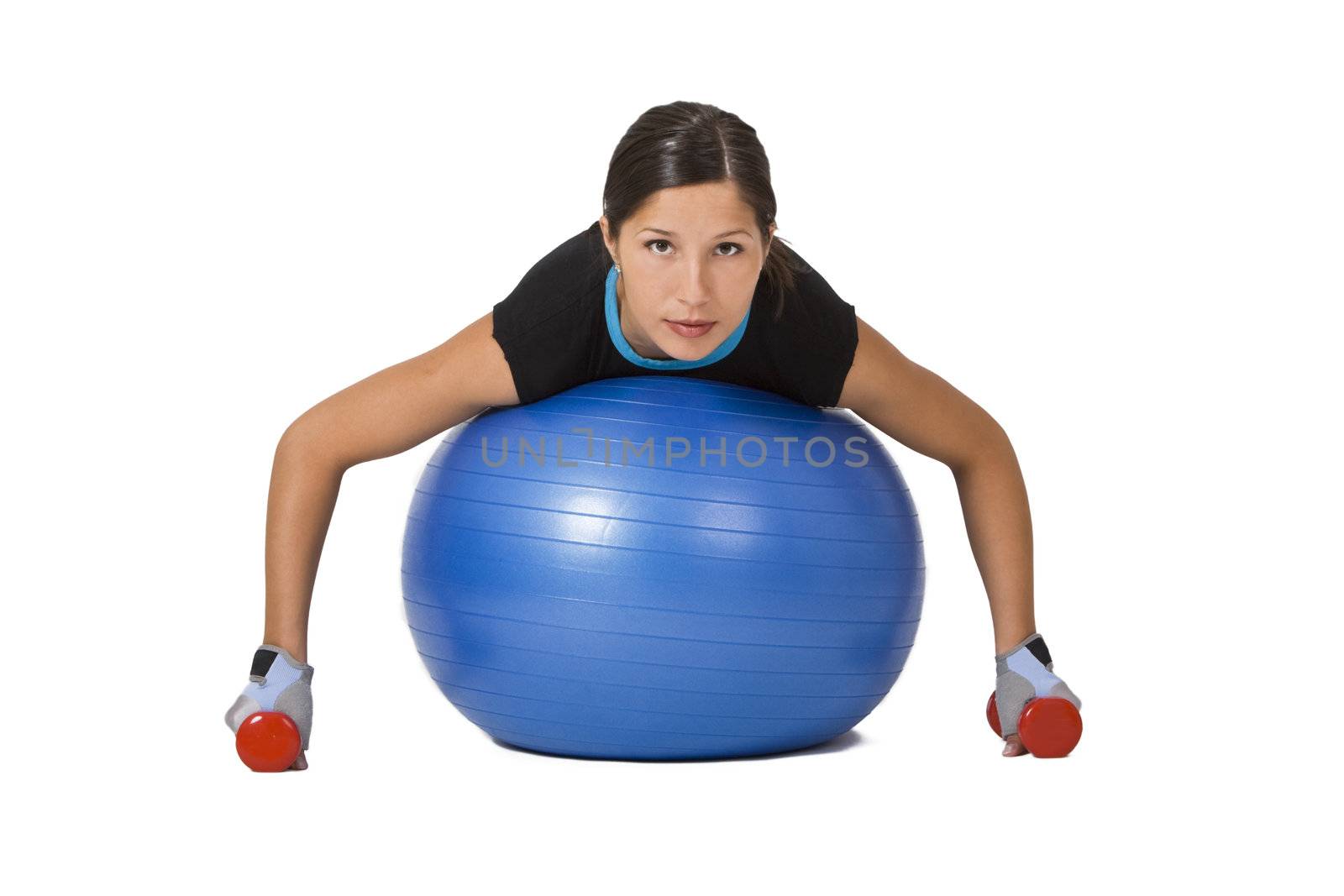 Young woman doing an exercise with barbells and a fitness ball 