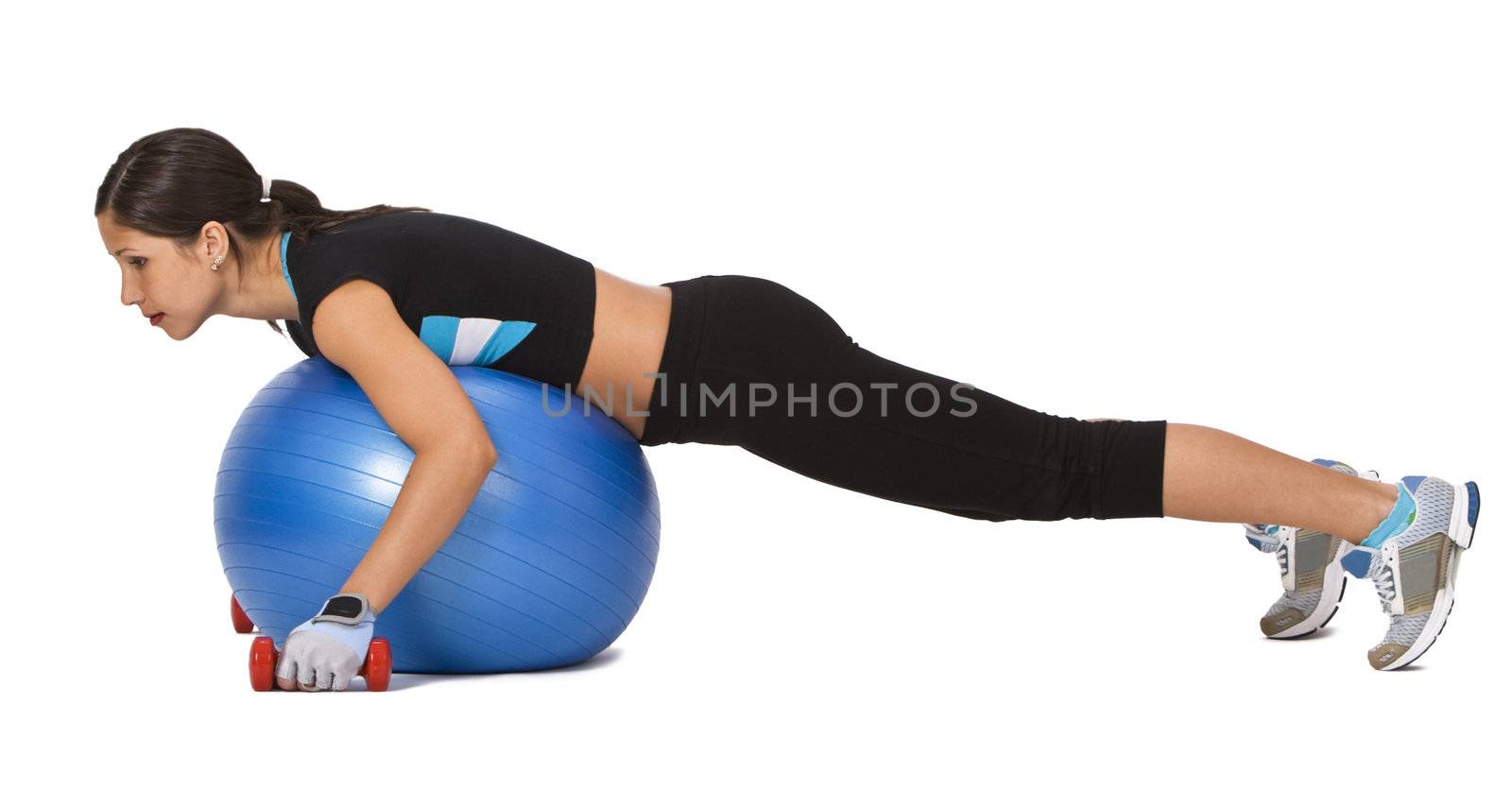 Young woman doing an exercise with barbells and a fitness ball 