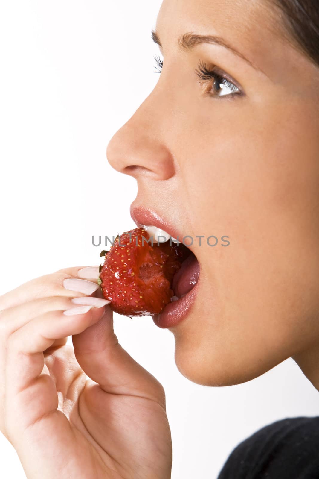Close-up of a woman mouth bitting into a bitten strawberry.