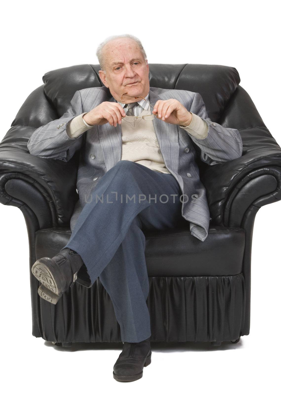 Portrait of a senior man sitting in an armchair and thinking deeply.Shot with Canon 70-200mm f/2.8L IS USM