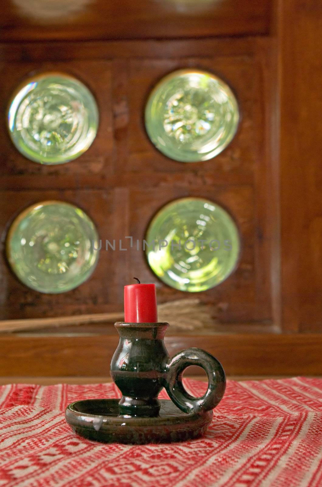 candle on a table in front of a window 