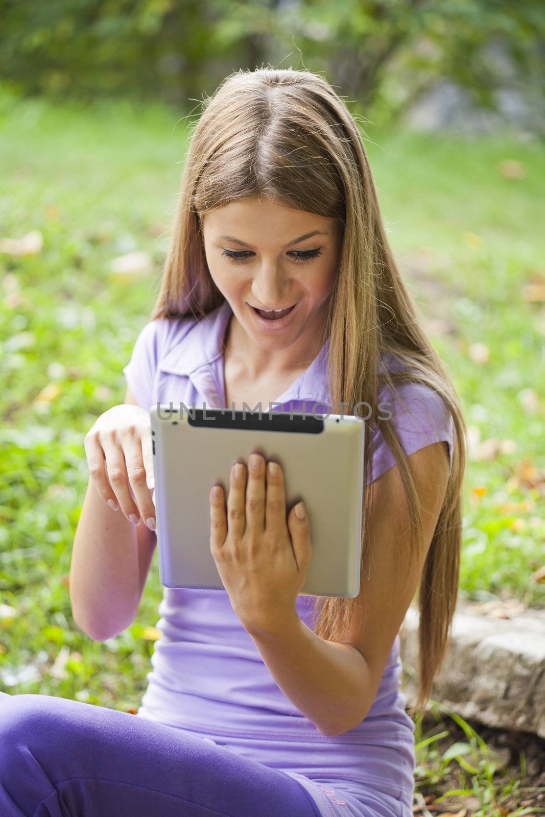 Beautiful Young Woman With Tablet Computer In Park