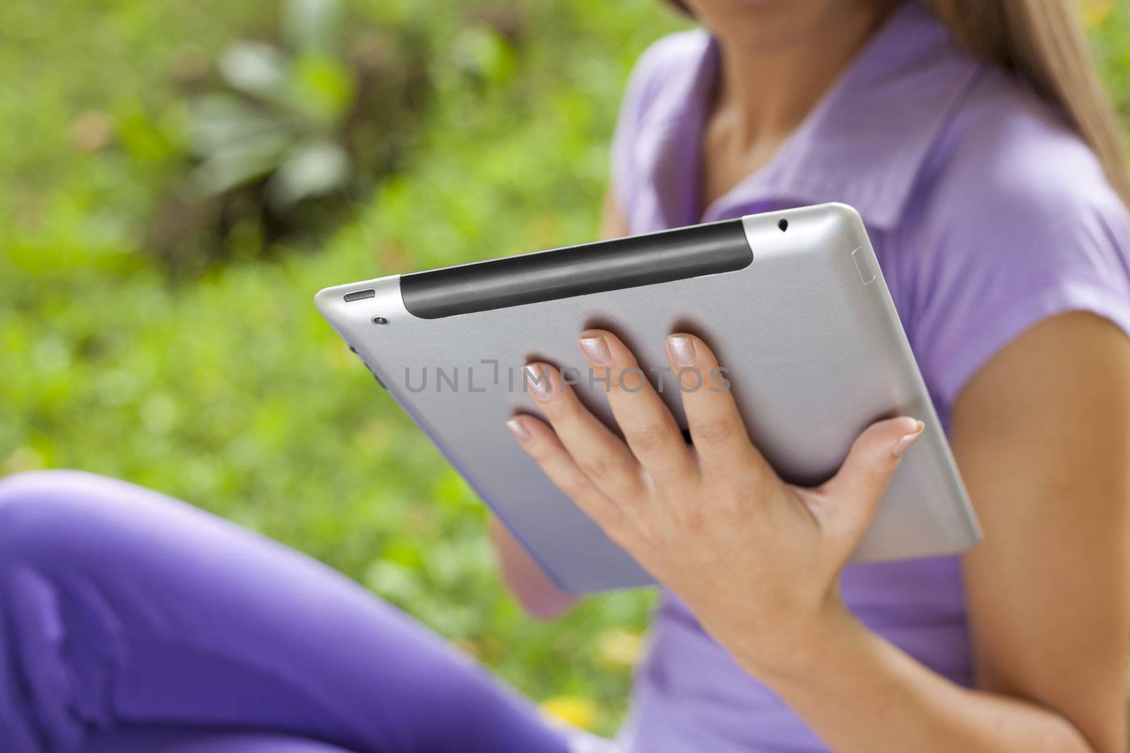 Tablet Computer On Hand Of Beautiful Young Woman In Park by adamr