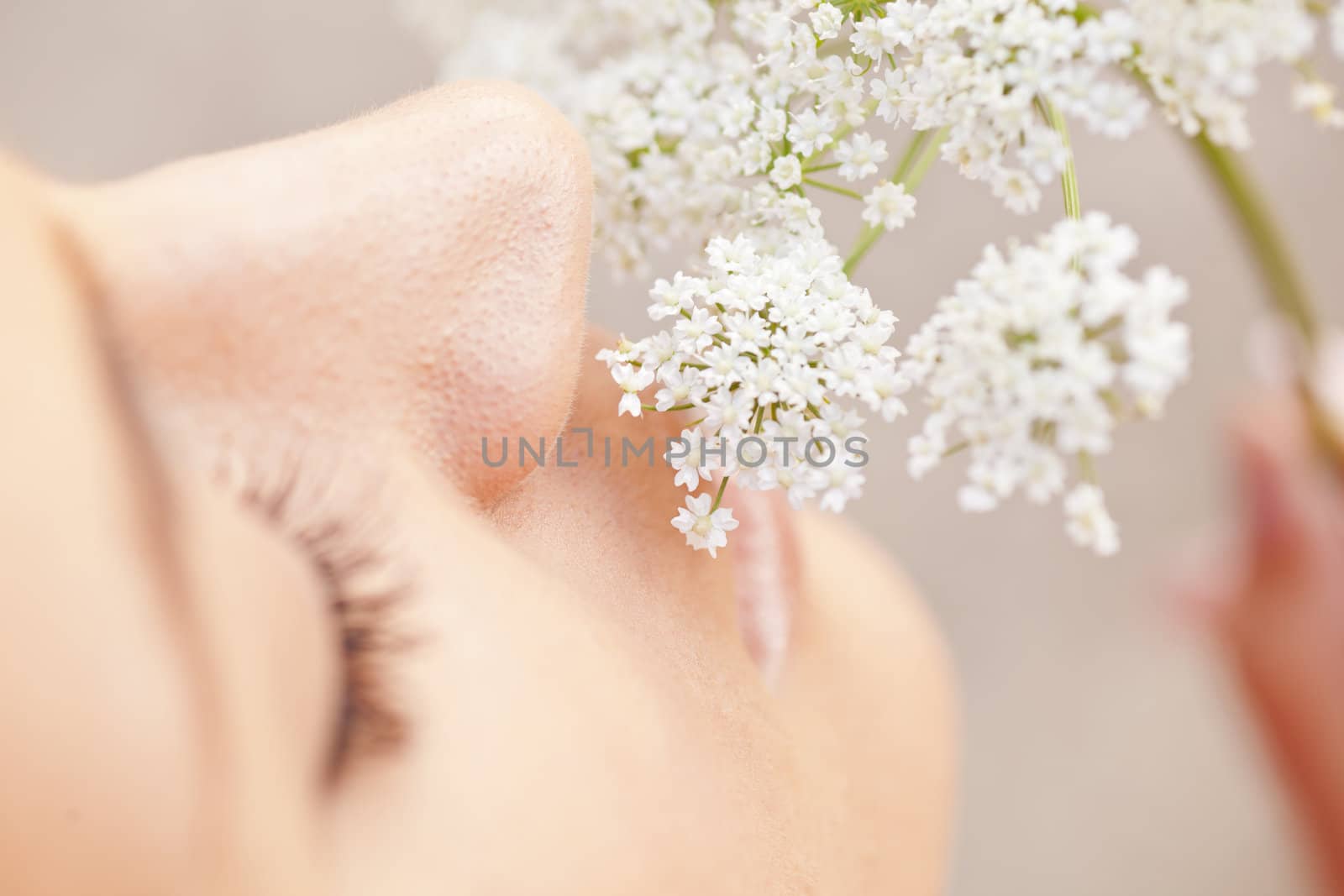 Woman smelling white flower, close-up macro shot of nose