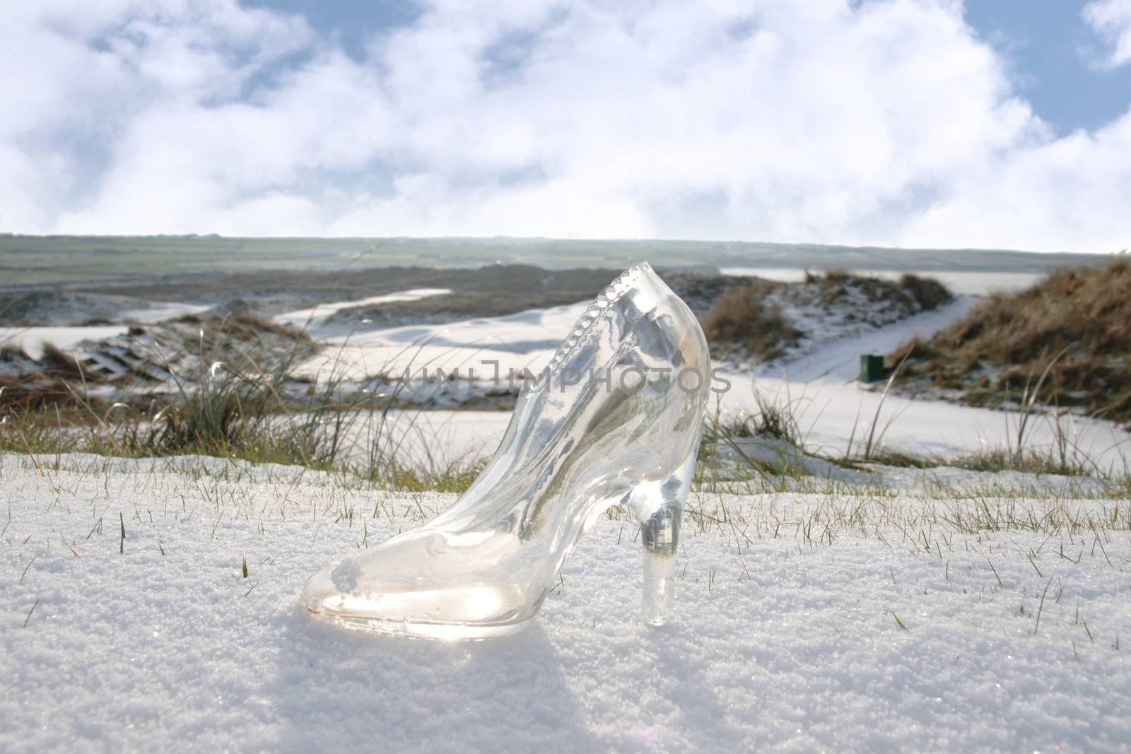 a crystal glass slipper in a snow covered irish golf course for a concept on ladies golf