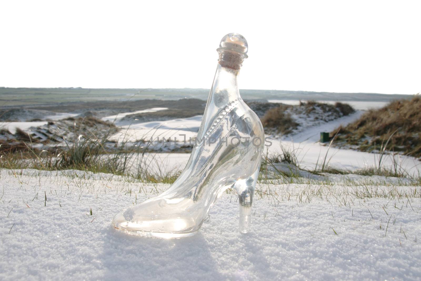 a crystal glass slipper in a snow covered irish golf course for a concept on ladies golf