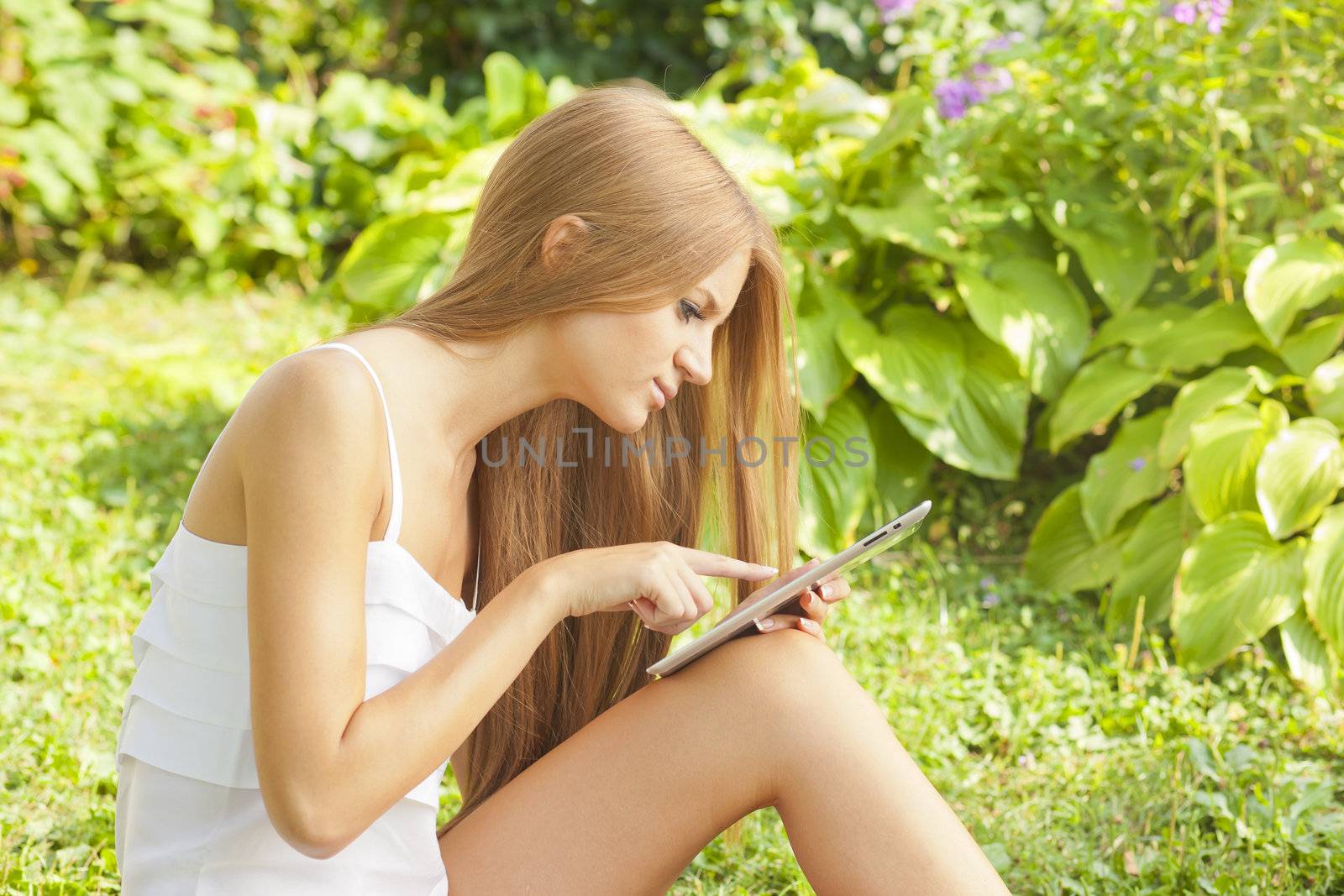 Beautiful Woman With Tablet Computer In Park Garden by adamr