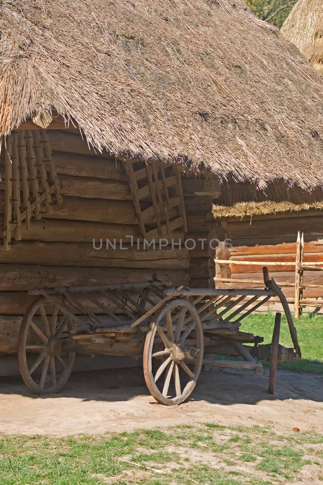 Old wooden wagon standing under the thatched roof