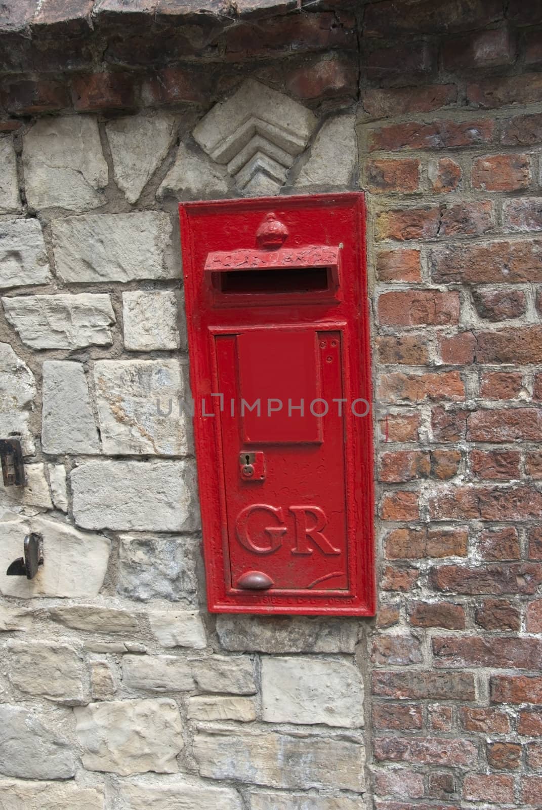 A Red British Post Box set in a stone wall