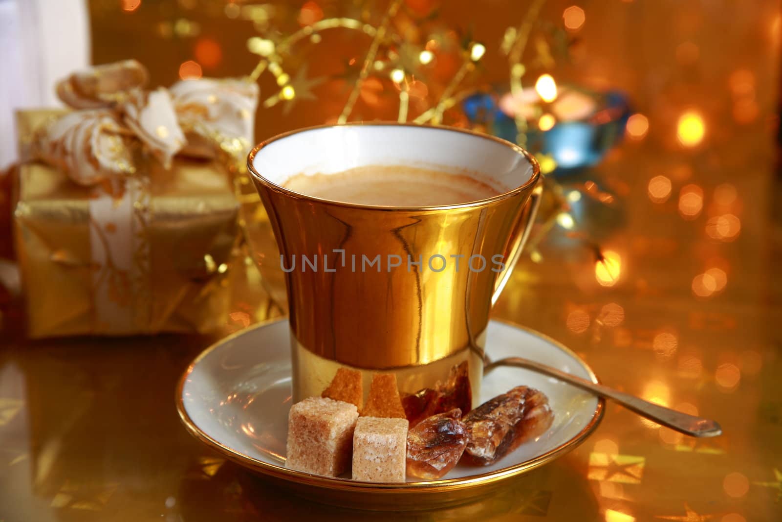Coffee cup with brown sugar on gold background with twinkle lights.