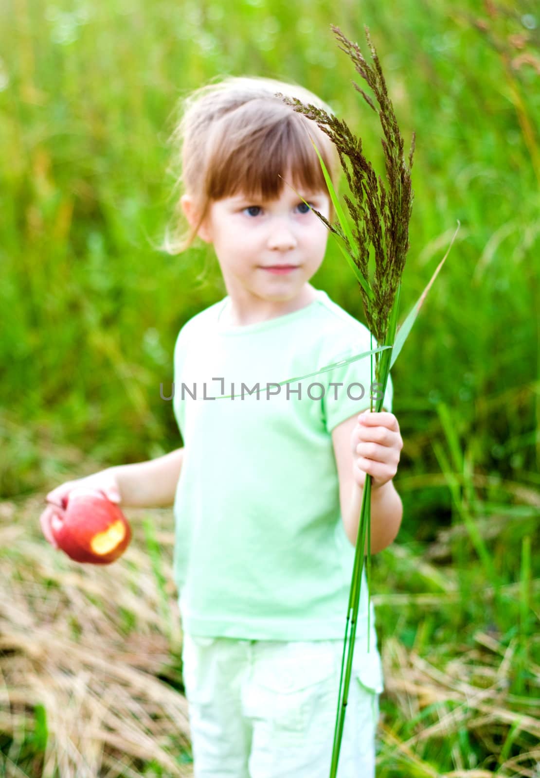 girl with bent-grass bouquet in summer meadow. focus on bouquet.