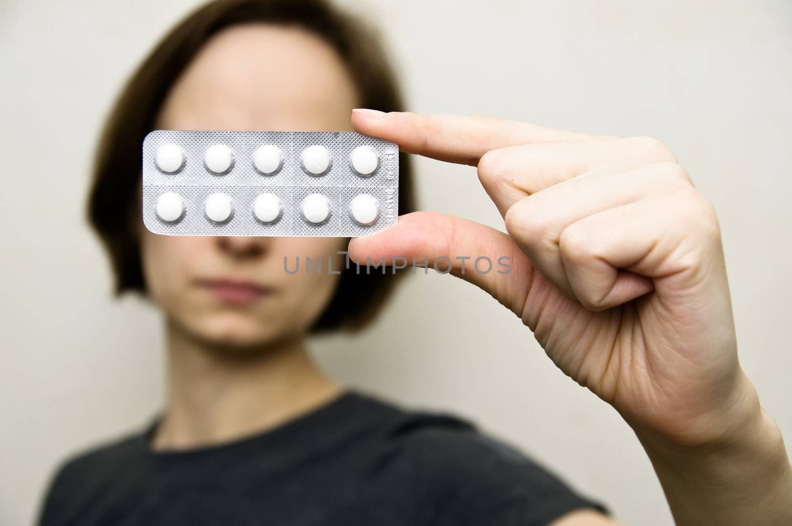 woman holds blister pack of pills