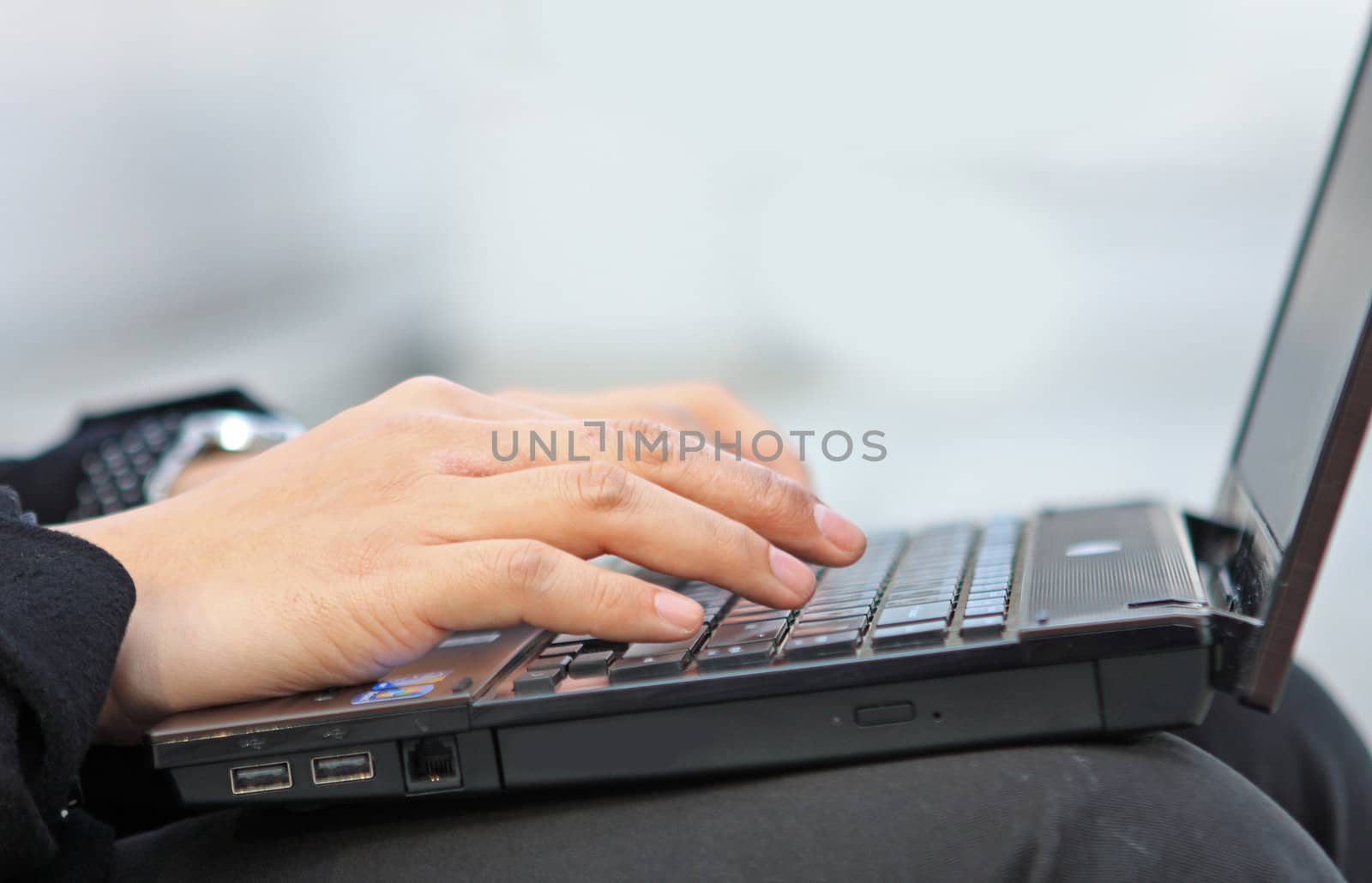 Hands typing on laptop computer keyboard close up