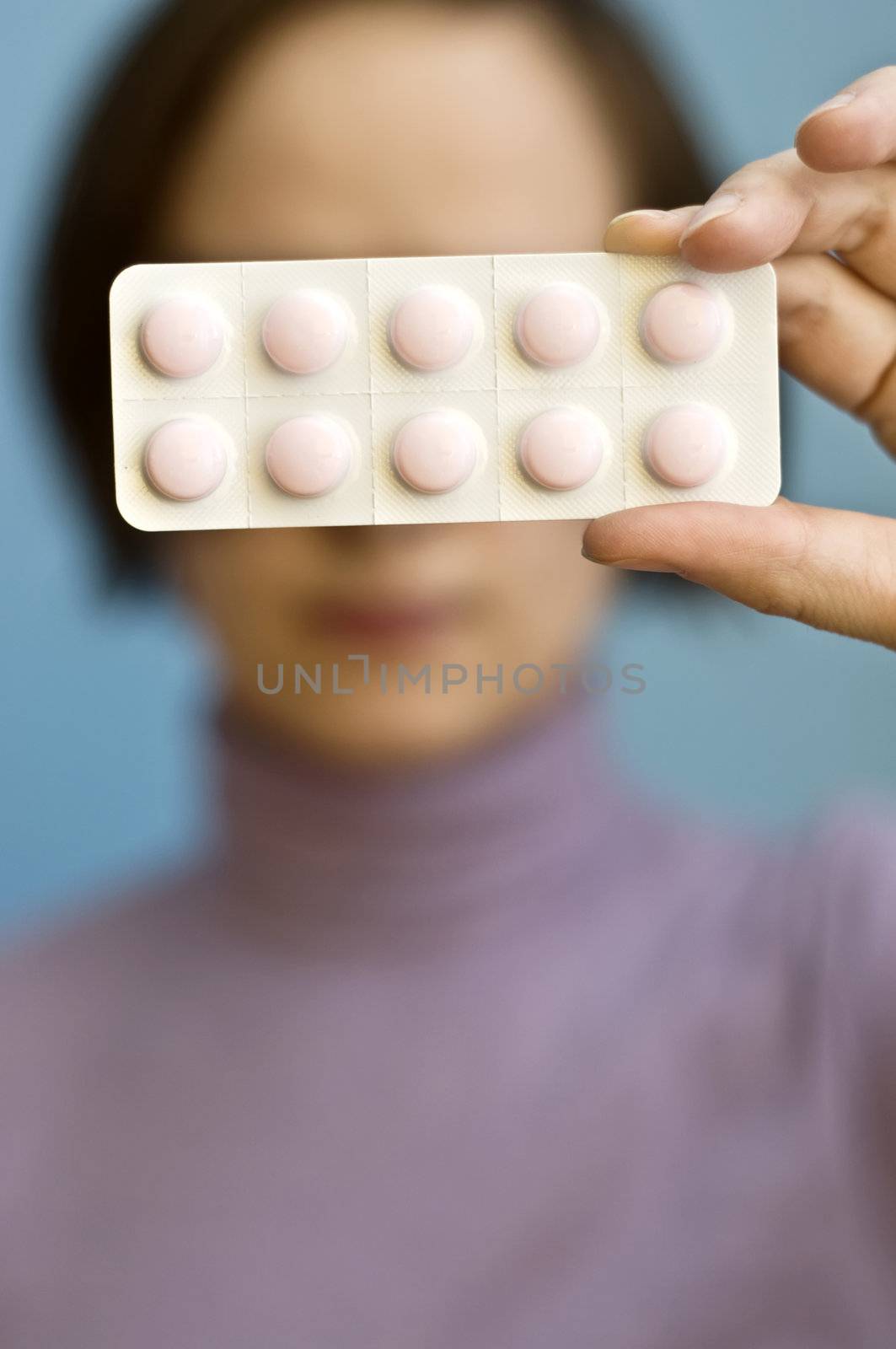 woman holds blister pack of pills