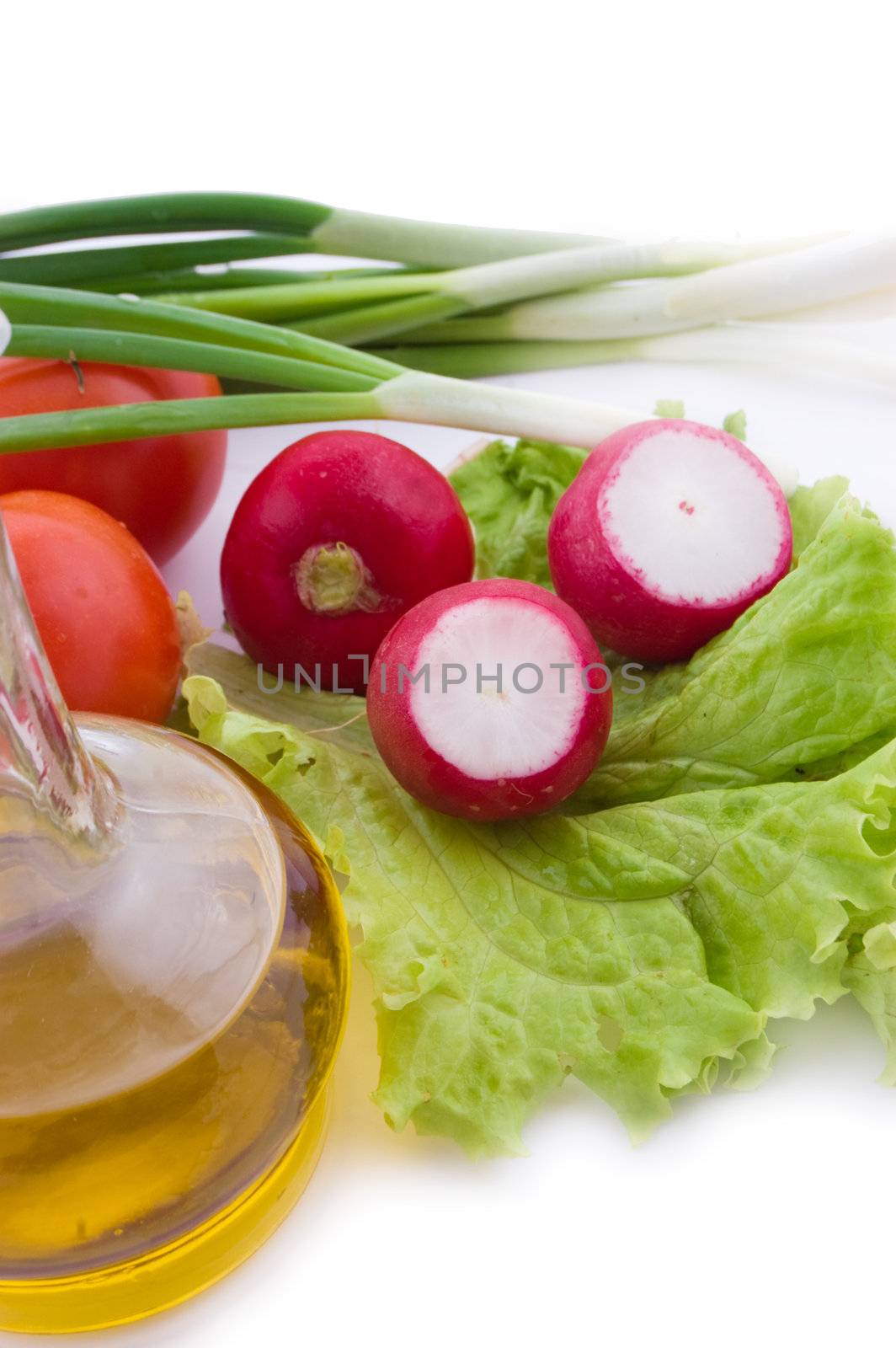 Radish on salad leaves, oil and onion on white