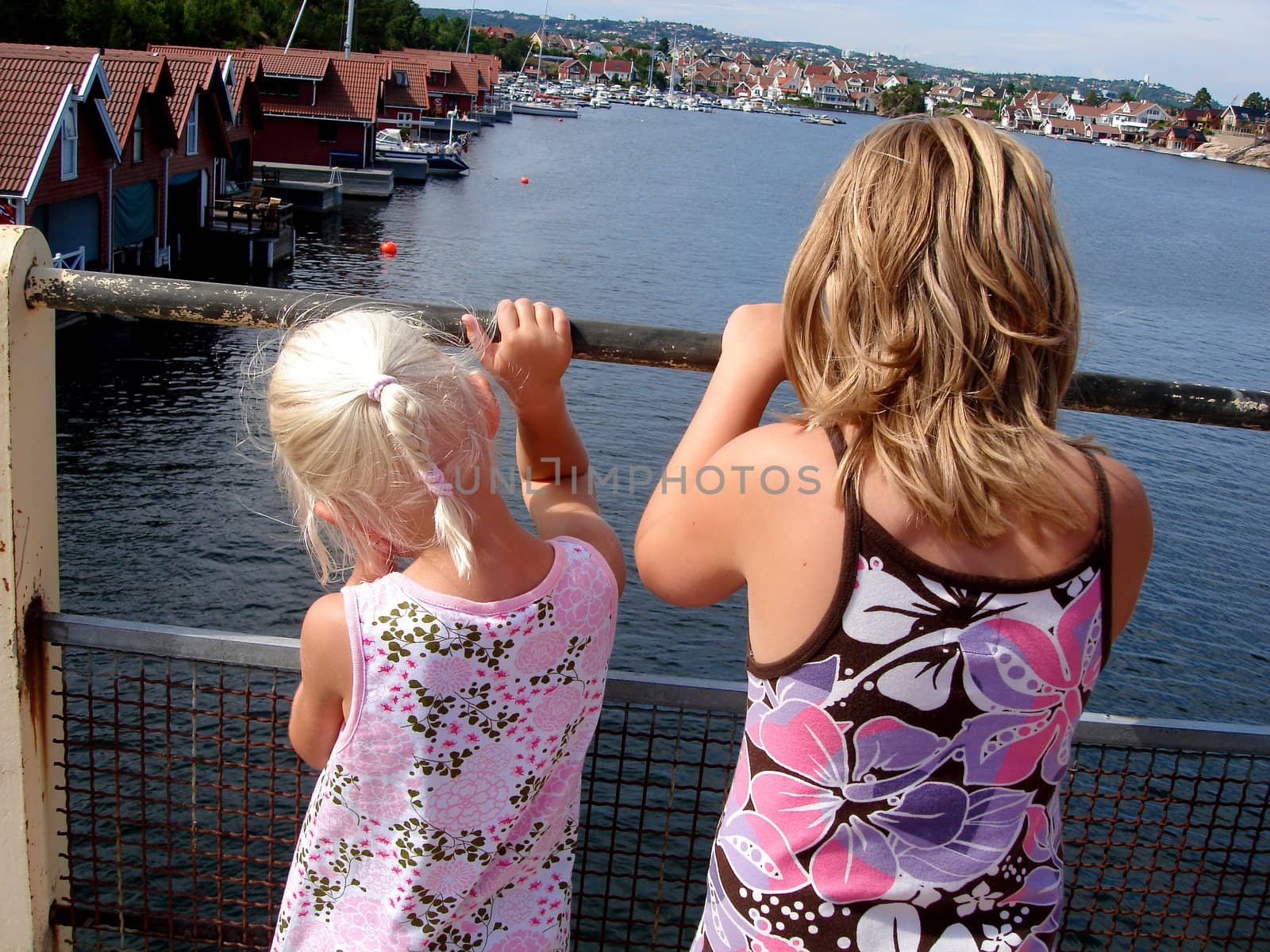 two girls looking over the sea, Kristiansand, Norway. Please note: No negative use allowed.