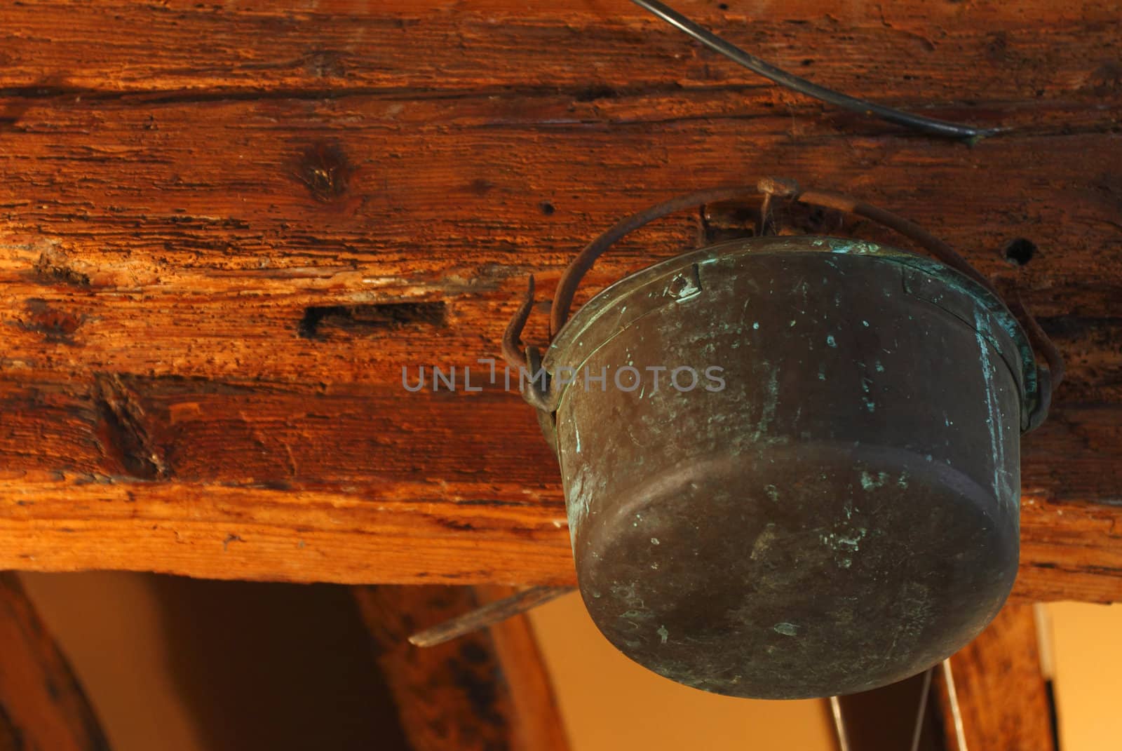 Old rusty copper pot hanging in a girder