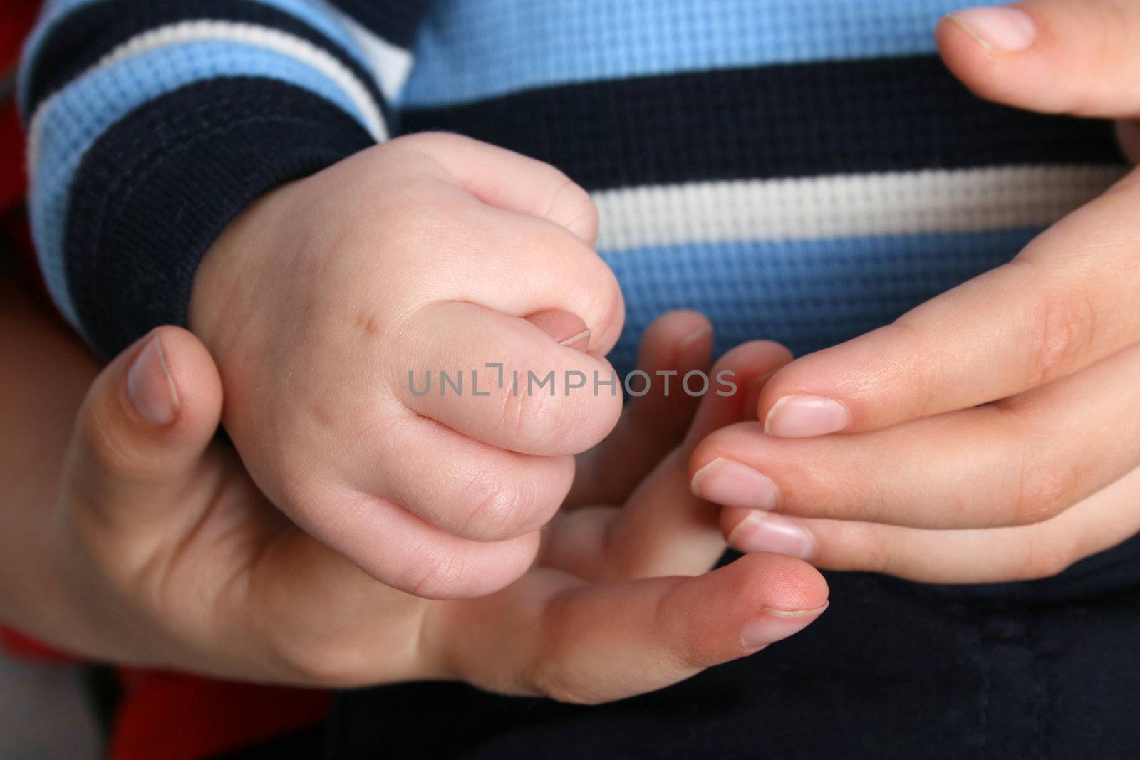 Young boy holding his baby brothers hands