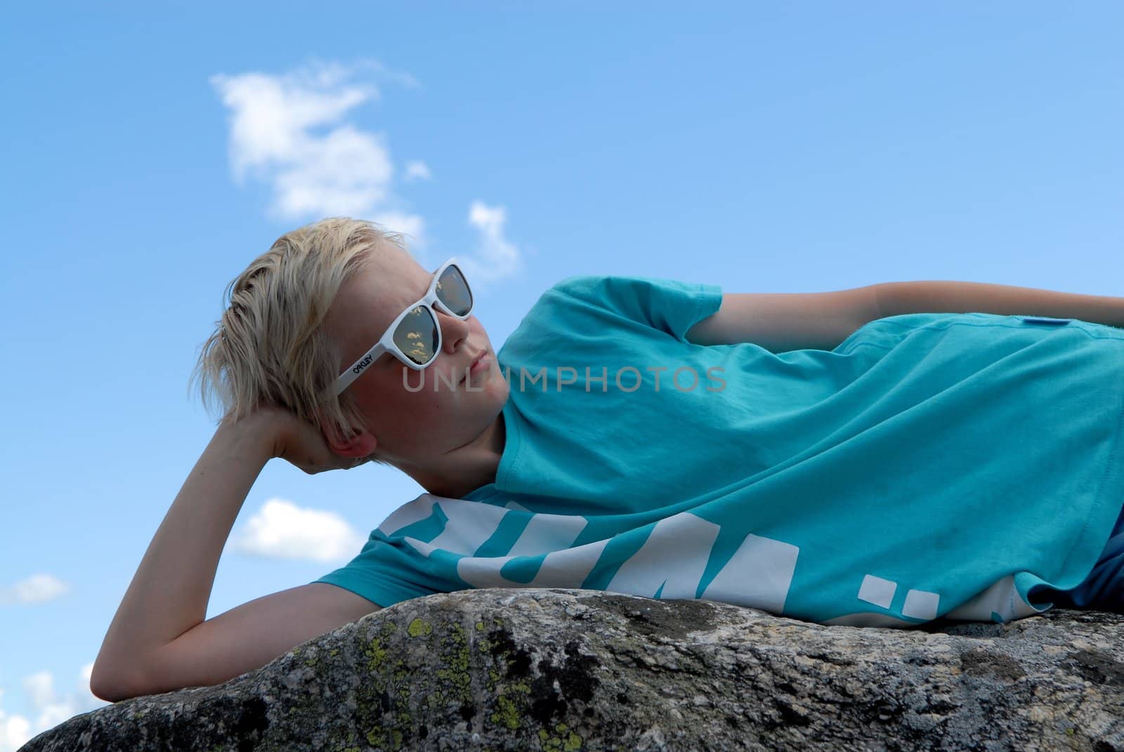 boy lying on a stone. Please note: No negative use allowed.