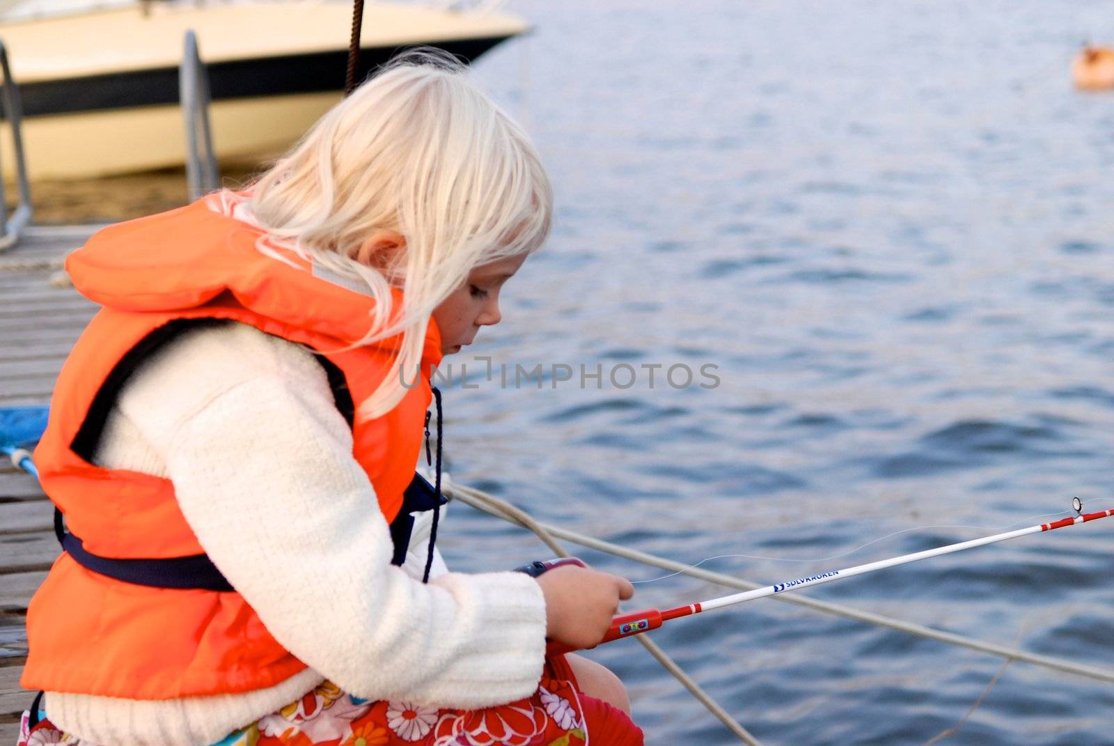 little girl fishing by the sea. Please note: No negative use allowed.