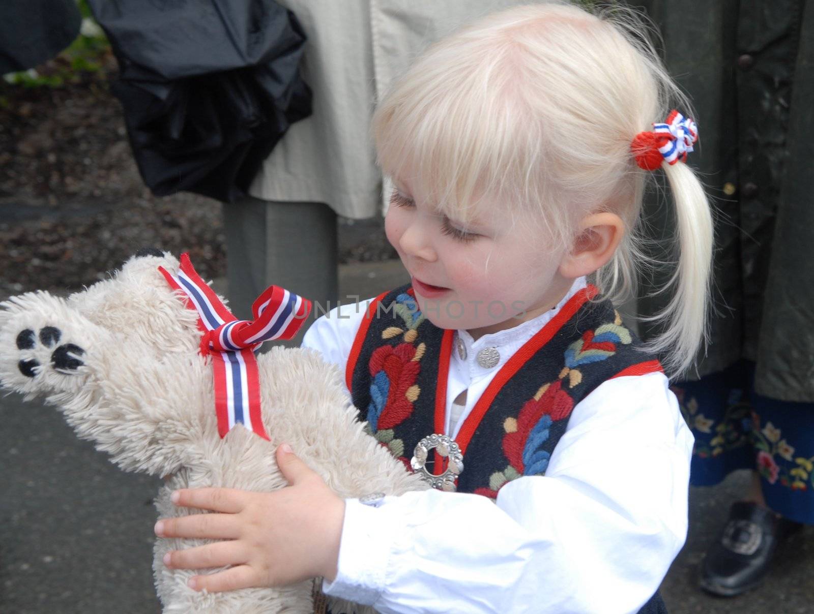 little girl playing with a toy bear. Please note: No negative use allowed.