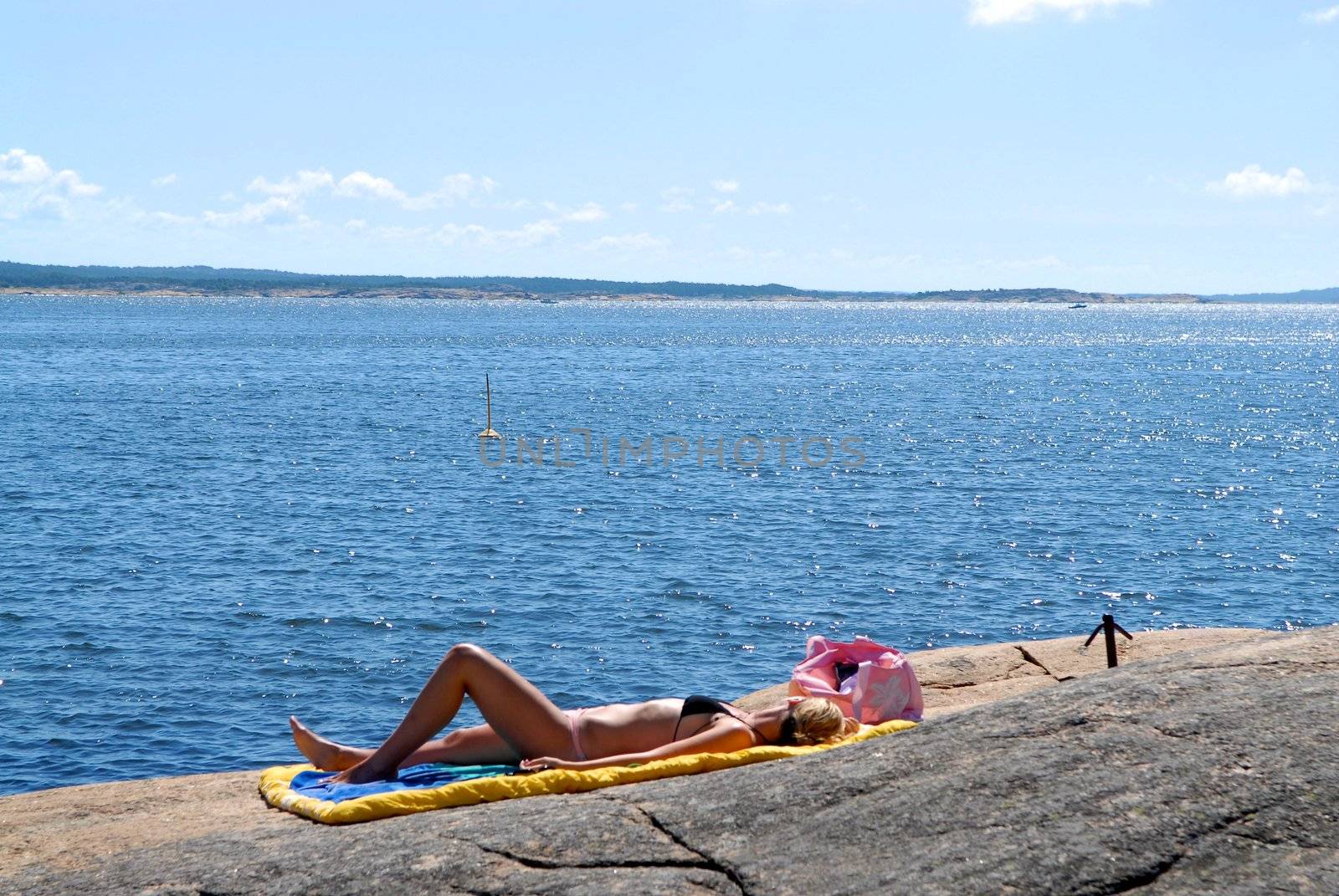 Scandinavian Lifestyle - sexy lady lying on the rock by Bildehagen