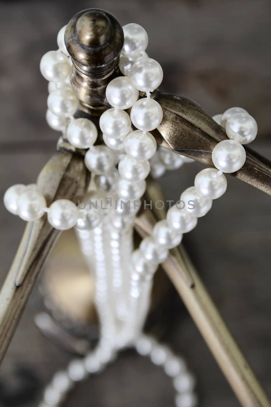 String of pearls hanging around an antique bronze stand