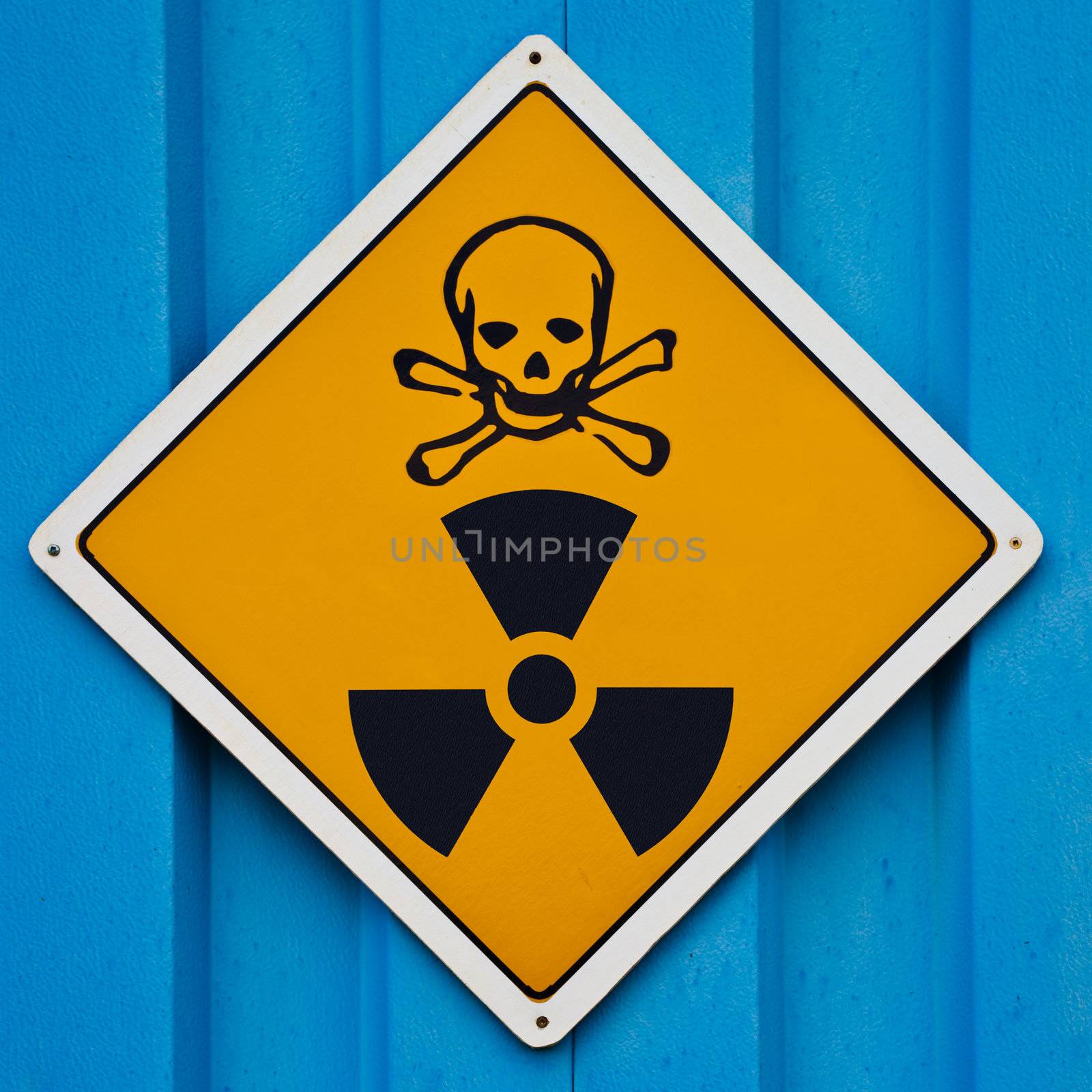 Deadly nuclear radiation warning sign with skull and crossbones on blue background.
