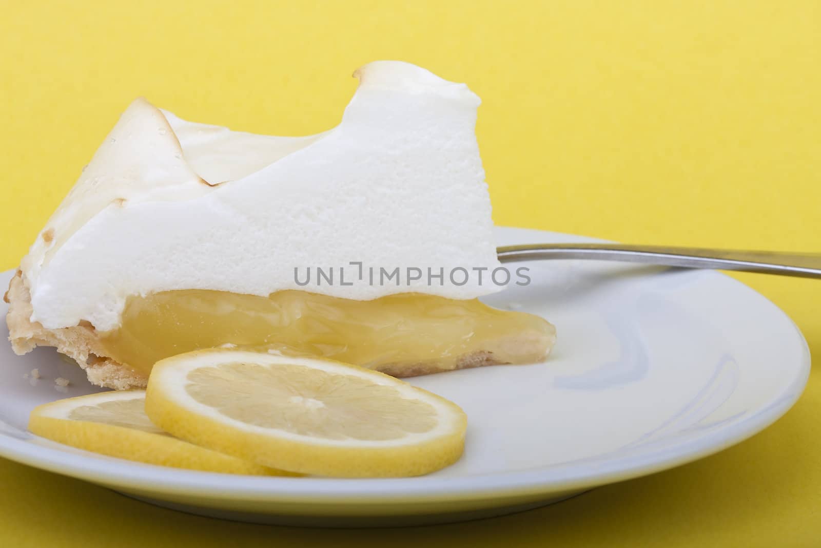 lemon meringue pie slices of lemon on a yellow background