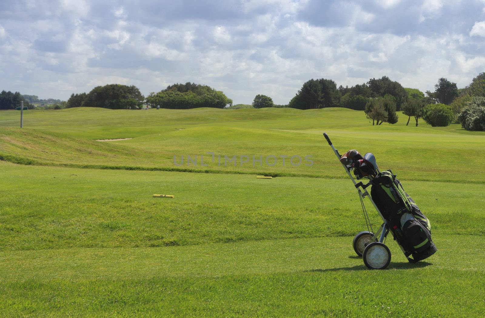 Golf equipment on a golf field in a cloudy day.