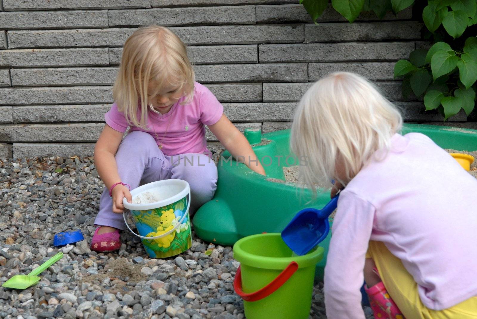 Scandinavian Lifestyle - girls playing sand and stones by Bildehagen