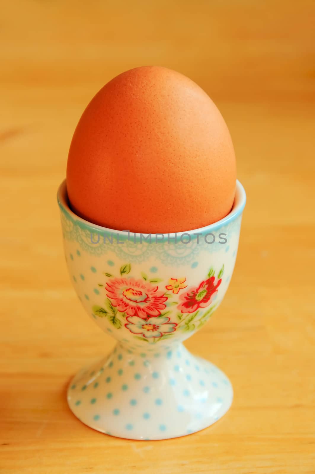 A single egg in egg cup on a kitchen table