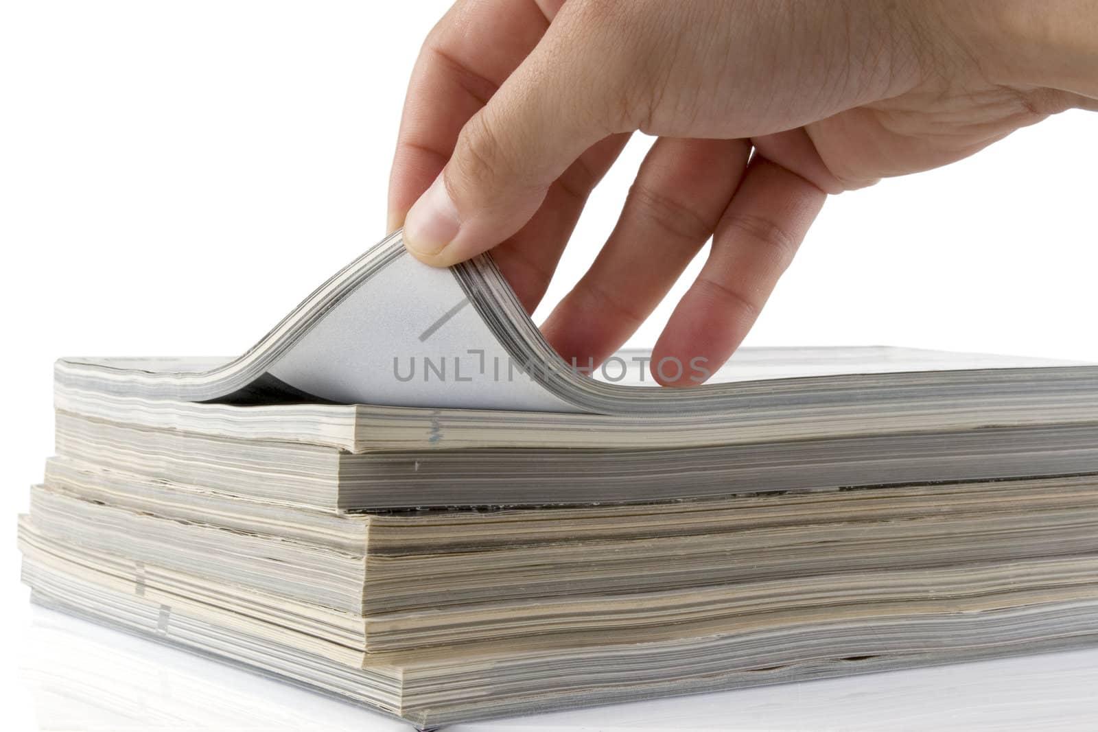 man hand browsing through stack of magazines 