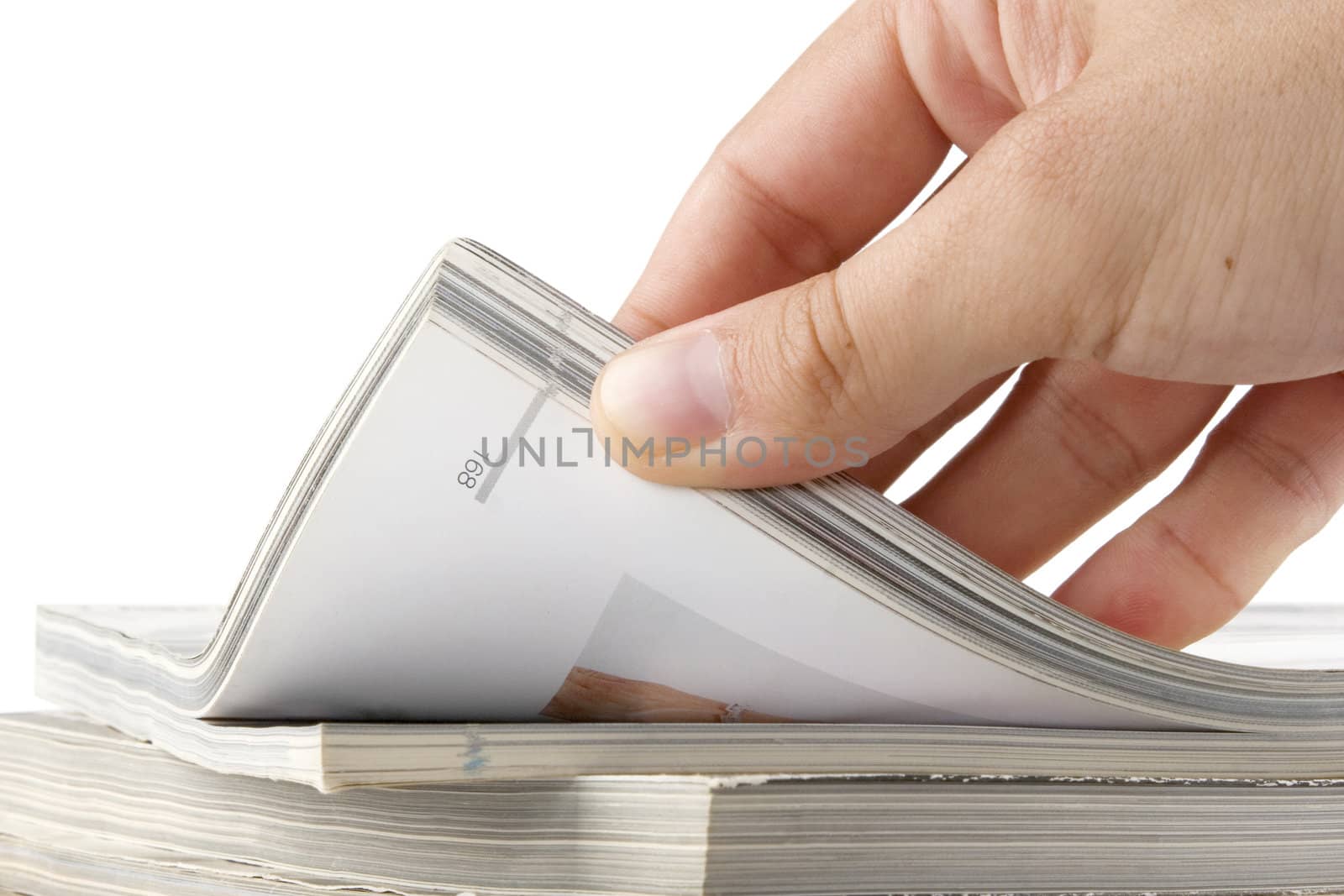 man hand browsing through stack of magazines