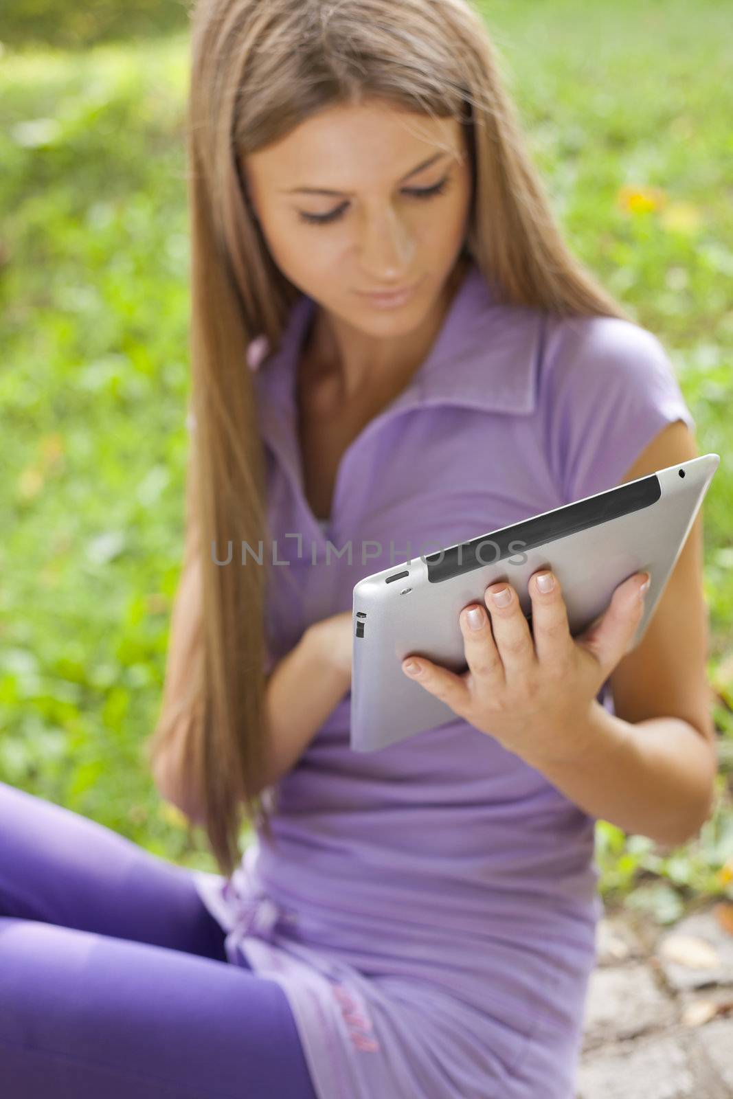 Beautiful Woman With Tablet Computer In Park by adamr