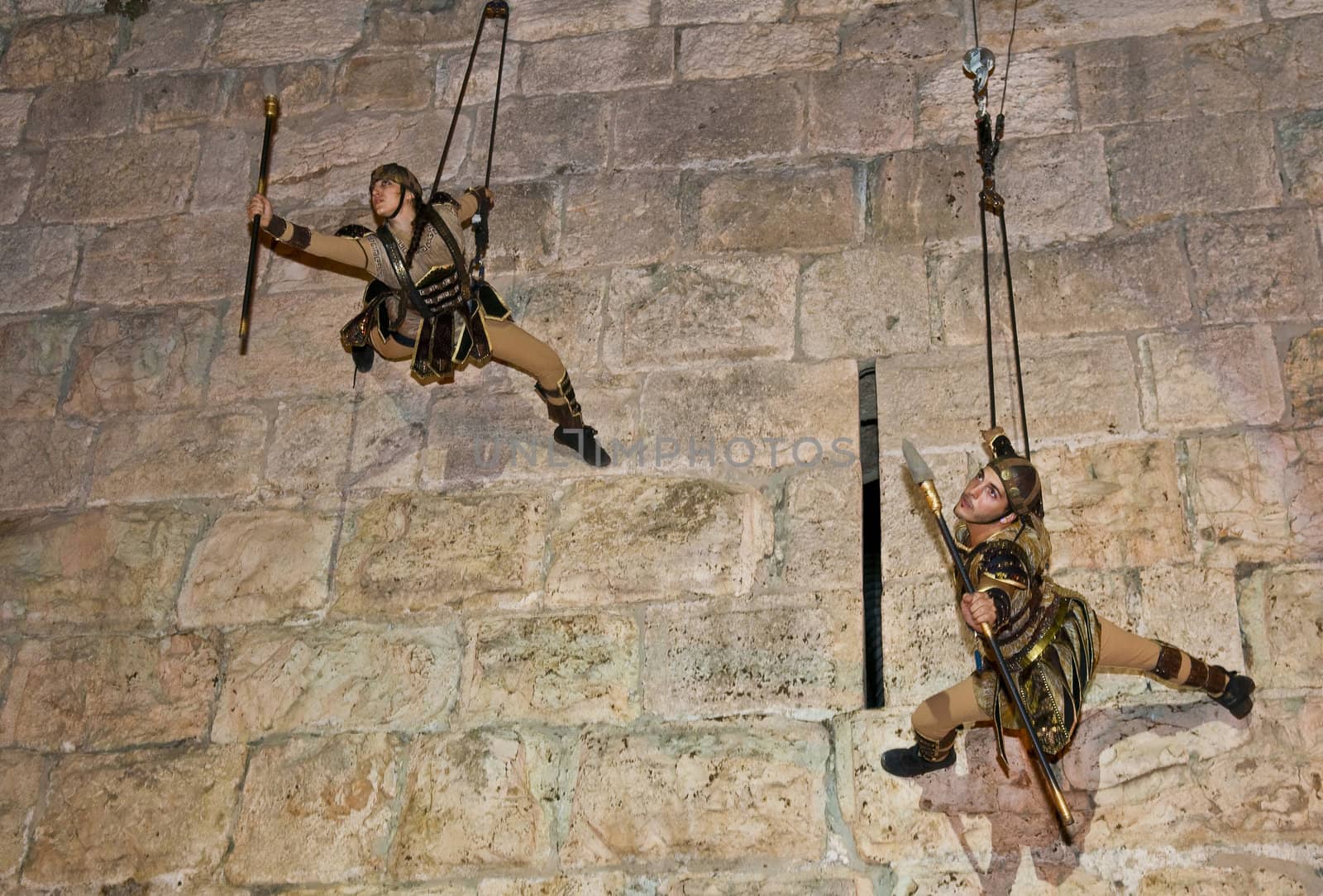 JERUSALEM - NOV 03 : An Israeli acrobats dressed as knight climbing on the old city walls in the annual medieval style knight festival held in the old city of Jerusalem on November 03 2011