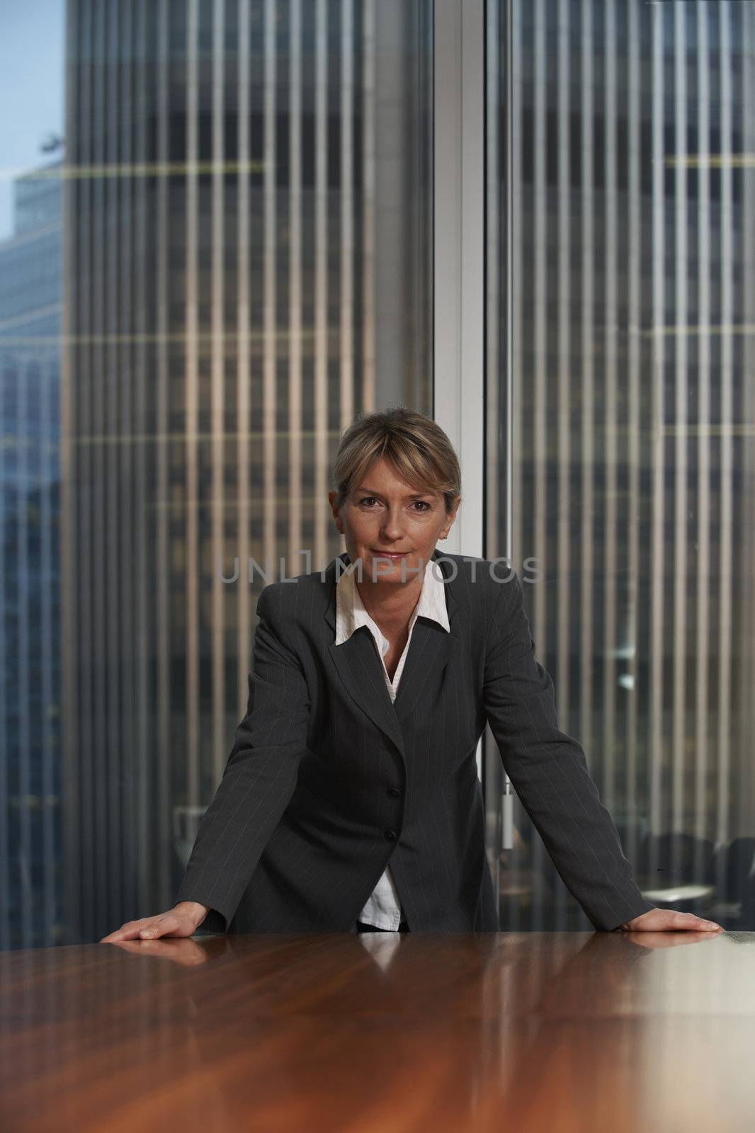 Business woman leaning on chair in boardroom looking at camera