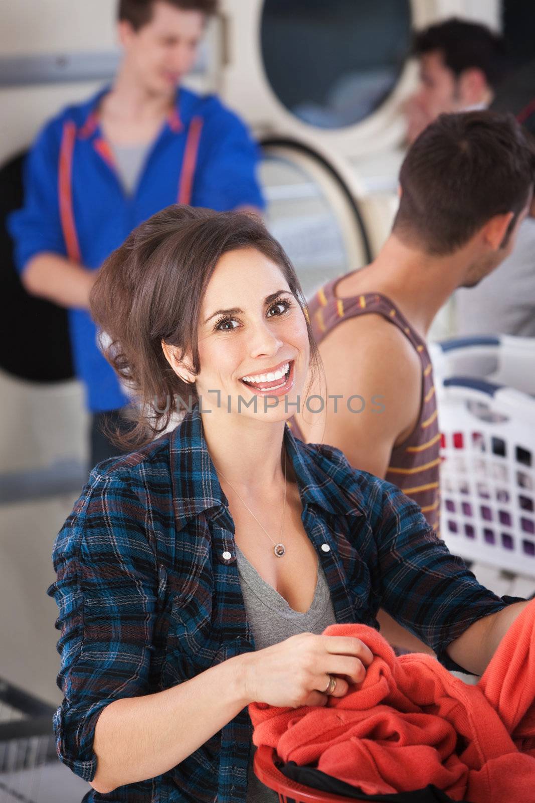 Young Caucasian woman smiles in the laundromat 