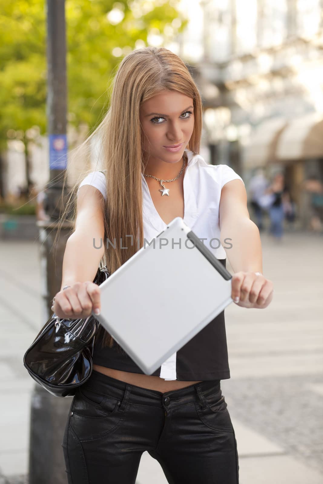 Young Beautiful Business Woman with tablet computer walking on urban street, downtown