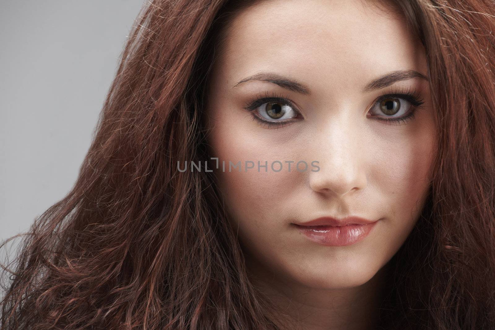 Portrait of beautiful young woman with make-up on grey background