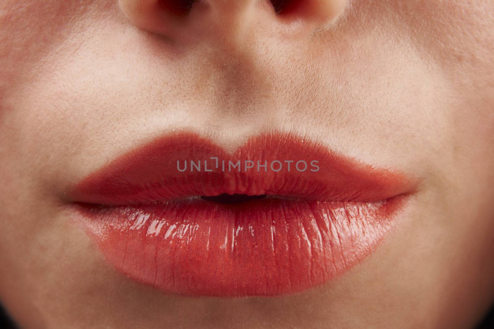close up of womans pouting lips with red lipstick